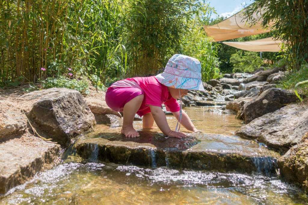 Spielen im Wasser mit UV-Schutzkleidung