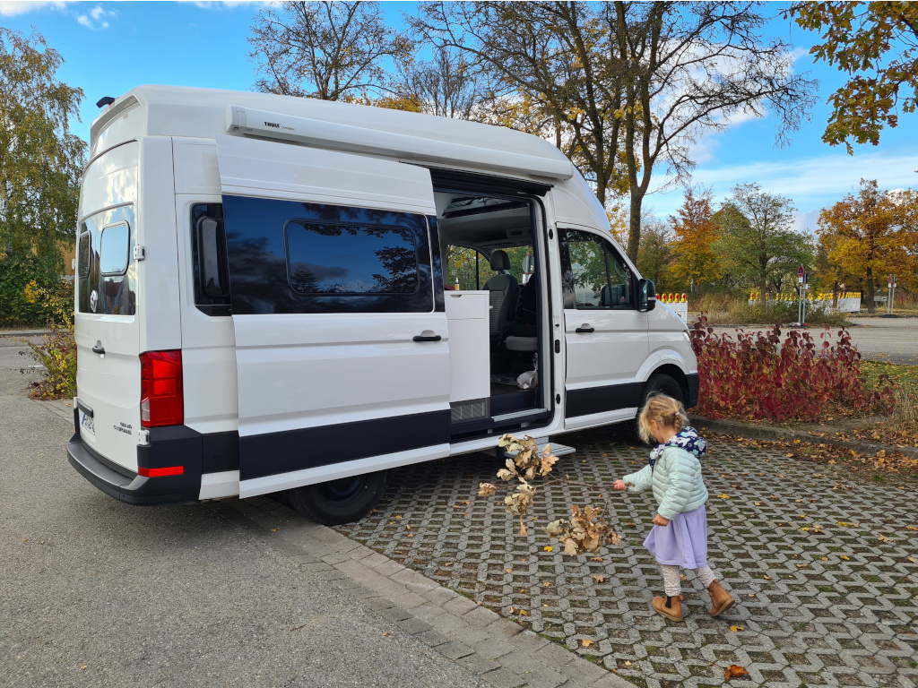 Camper Modelle Elternzeit:Kind spielt vor Camper Van